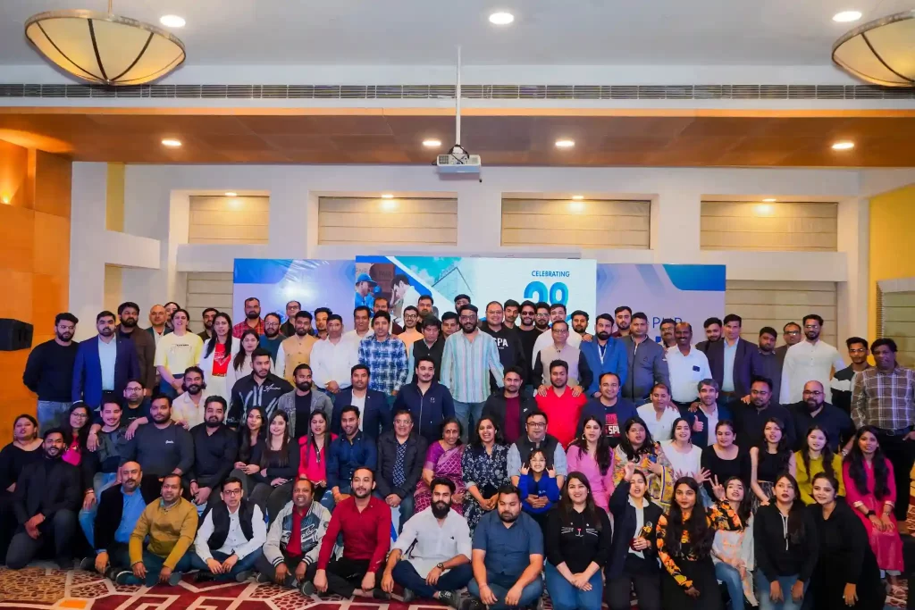 A team of professionals gathered at a corporate event, celebrating a thriving, employee-centric workplace culture.