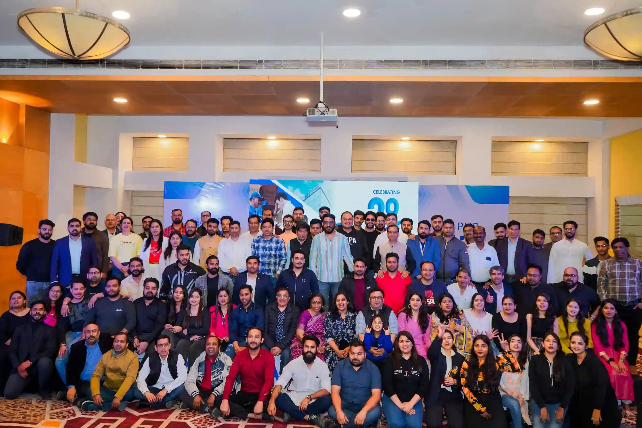 A team of professionals gathered at a corporate event, celebrating a thriving, employee-centric workplace culture.